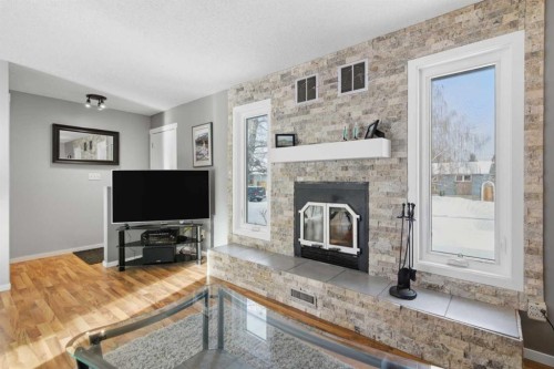 127 Queen Tamara Road Se, Calgary, AB - Indoor Photo Showing Living Room With Fireplace