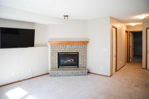 445 Rocky Ridge Bay Nw, Calgary, AB - Indoor Photo Showing Living Room With Fireplace