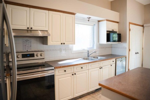 445 Rocky Ridge Bay Nw, Calgary, AB - Indoor Photo Showing Kitchen With Double Sink