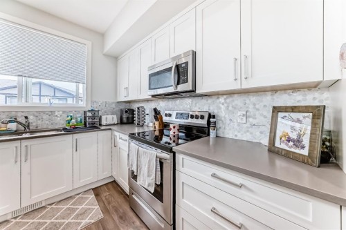 1703 Jumping Pound Common, Cochrane, AB - Indoor Photo Showing Kitchen With Double Sink
