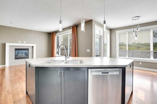 157 Rainbow Falls Boulevard, Chestermere, AB - Indoor Photo Showing Kitchen With Fireplace With Double Sink With Upgraded Kitchen