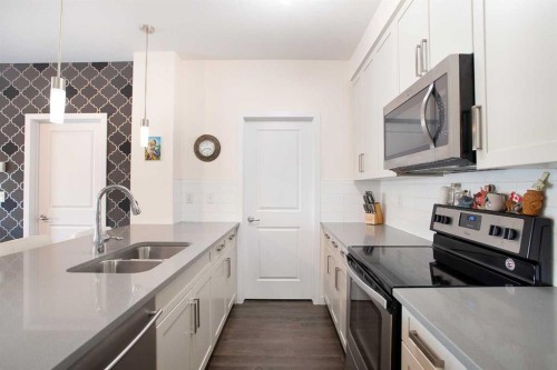 103-200 Cranfield Common Se, Calgary, AB - Indoor Photo Showing Kitchen With Stainless Steel Kitchen With Double Sink With Upgraded Kitchen