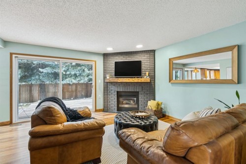 715 Coach Bluff Crescent Sw, Calgary, AB - Indoor Photo Showing Living Room With Fireplace