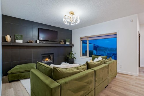 203 Sunset Circle, Cochrane, AB - Indoor Photo Showing Living Room With Fireplace