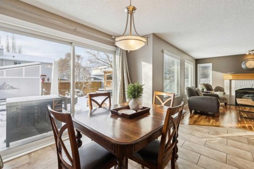 33 River Rock Crescent Se, Calgary, AB - Indoor Photo Showing Dining Room With Fireplace