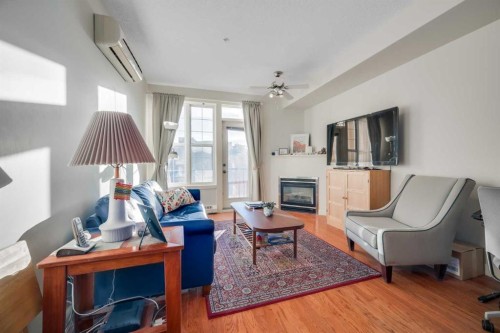 301-208 Holy Cross Lane Sw, Calgary, AB - Indoor Photo Showing Living Room With Fireplace