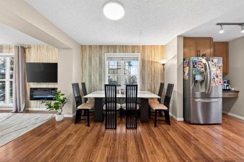 303 New Brighton Villas Se, Calgary, AB - Indoor Photo Showing Dining Room With Fireplace
