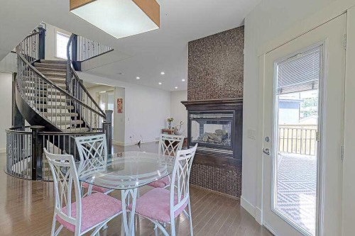 16 Rockcliff Point Nw, Calgary, AB - Indoor Photo Showing Dining Room With Fireplace
