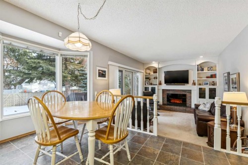 212 Oakside Circle Sw, Calgary, AB - Indoor Photo Showing Dining Room With Fireplace