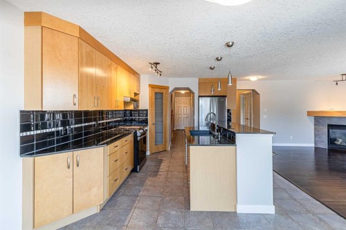 173 Silverado Plains Close Sw, Calgary, AB - Indoor Photo Showing Kitchen With Fireplace