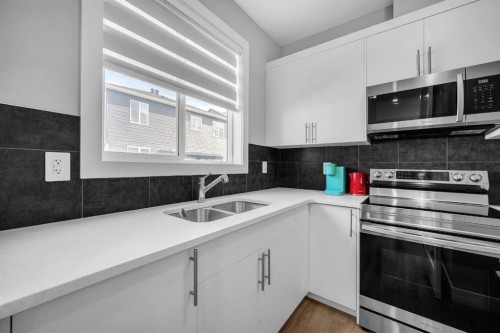 155 Carringham Way Nw, Calgary, AB - Indoor Photo Showing Kitchen With Double Sink