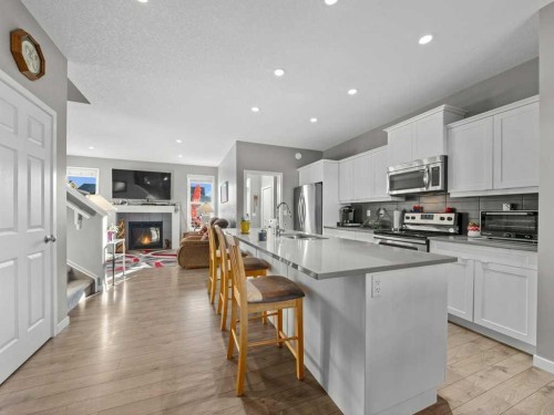 33 Amery Green, Crossfield, AB - Indoor Photo Showing Kitchen With Fireplace With Upgraded Kitchen