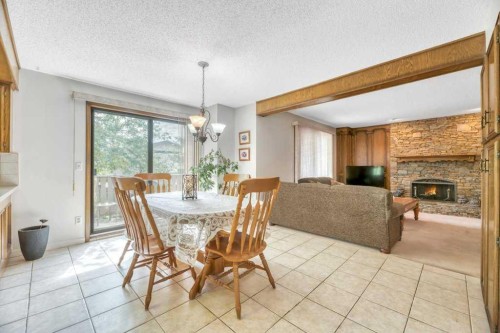 77 Edgewood Rise Nw, Calgary, AB - Indoor Photo Showing Dining Room With Fireplace