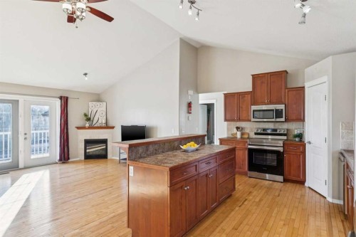 100B Westview Drive, Nanton, AB - Indoor Photo Showing Kitchen With Fireplace With Stainless Steel Kitchen