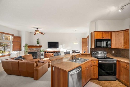 201-85 Dyrgas Gate, Canmore, AB - Indoor Photo Showing Kitchen With Fireplace With Double Sink