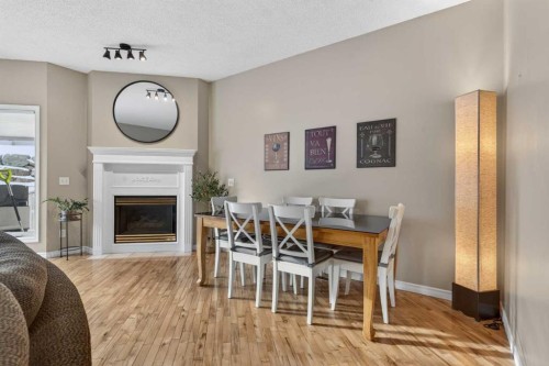 42 Hamptons Link Nw, Calgary, AB - Indoor Photo Showing Dining Room With Fireplace