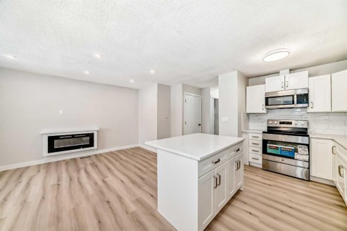 937 Marcombe Drive Ne, Calgary, AB - Indoor Photo Showing Kitchen With Fireplace