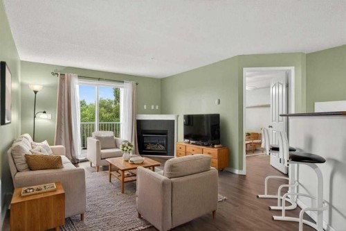4316-10 Prestwick Bay Se, Calgary, AB - Indoor Photo Showing Living Room With Fireplace