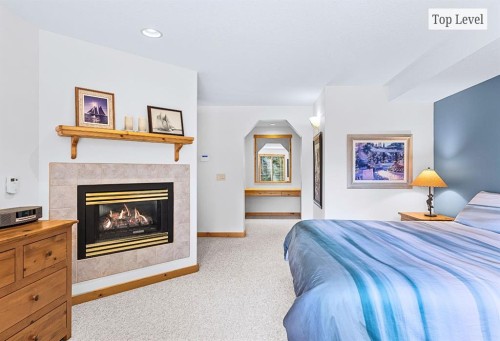 18 Juniper Ridge, Canmore, AB - Indoor Photo Showing Bedroom With Fireplace