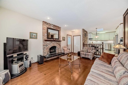 111 Oakside Road Sw, Calgary, AB - Indoor Photo Showing Living Room With Fireplace