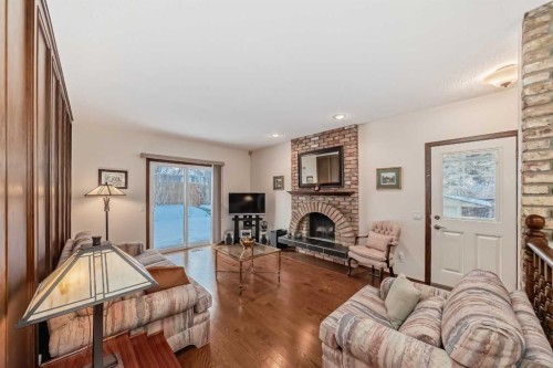 111 Oakside Road Sw, Calgary, AB - Indoor Photo Showing Living Room With Fireplace