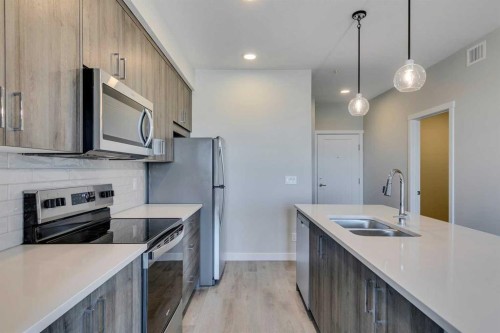 408-660 Shawnee Square Sw, Calgary, AB - Indoor Photo Showing Kitchen With Stainless Steel Kitchen With Double Sink With Upgraded Kitchen