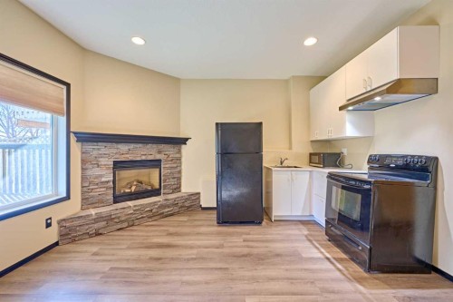 131 Arbour Wood Close Nw, Calgary, AB - Indoor Photo Showing Kitchen With Fireplace