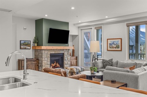 313-1408 Spring Creek Gate, Canmore, AB - Indoor Photo Showing Living Room With Fireplace