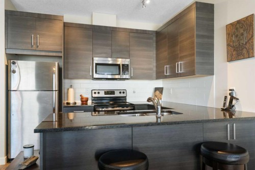 1403 Jumping Pound Common, Cochrane, AB - Indoor Photo Showing Kitchen With Double Sink With Upgraded Kitchen