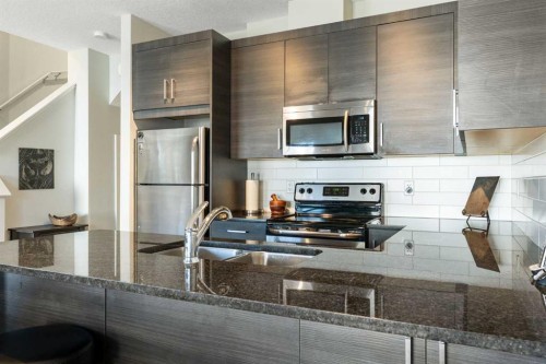 1403 Jumping Pound Common, Cochrane, AB - Indoor Photo Showing Kitchen With Double Sink With Upgraded Kitchen