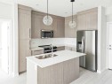 2413-111 Wolf Creek Drive Se, Calgary, AB  - Indoor Photo Showing Kitchen With Stainless Steel Kitchen With Double Sink With Upgraded Kitchen 