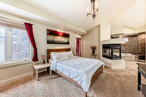 36 Dalrymple Green Nw, Calgary, AB - Indoor Photo Showing Bedroom With Fireplace