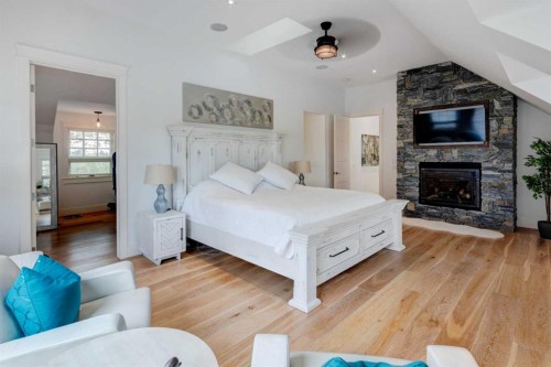 84 Eagle Butte Ranch, Rural Rocky View County, AB - Indoor Photo Showing Bedroom With Fireplace
