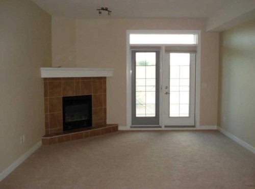 206-1005B Westmount Drive, Strathmore, AB - Indoor Photo Showing Living Room With Fireplace