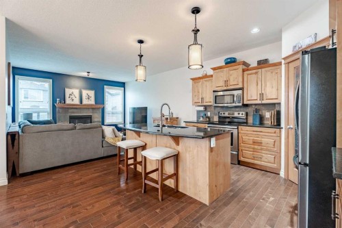 2937 Prairie Springs Grove Sw, Airdrie, AB - Indoor Photo Showing Kitchen With Fireplace With Upgraded Kitchen