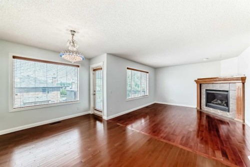 234 Panatella Boulevard Nw, Calgary, AB - Indoor Photo Showing Living Room With Fireplace