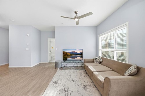 101-4250 Seton Drive Se, Calgary, AB - Indoor Photo Showing Living Room With Fireplace