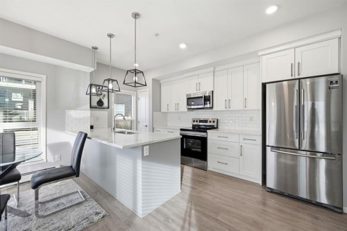 101-4250 Seton Drive Se, Calgary, AB - Indoor Photo Showing Kitchen With Stainless Steel Kitchen With Upgraded Kitchen