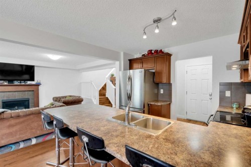 209 Windford Park Sw, Airdrie, AB - Indoor Photo Showing Kitchen With Fireplace With Double Sink