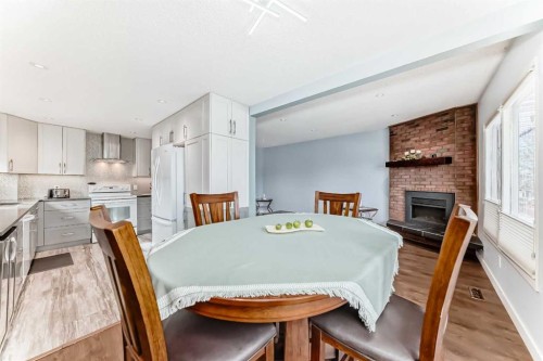 52A Queen Alexandra Close Se, Calgary, AB - Indoor Photo Showing Dining Room With Fireplace