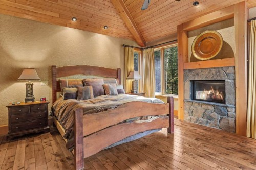 163 Cairns Landing, Canmore, AB - Indoor Photo Showing Bedroom With Fireplace