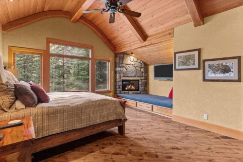 163 Cairns Landing, Canmore, AB - Indoor Photo Showing Bedroom With Fireplace