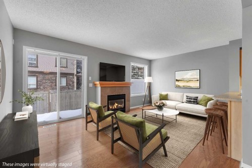 68 Panatella Villas Nw, Calgary, AB - Indoor Photo Showing Living Room With Fireplace