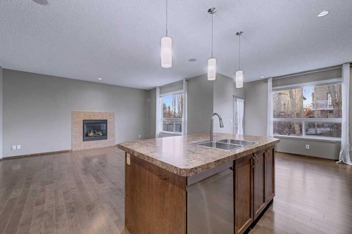 244 Eversyde Mews Sw, Calgary, AB - Indoor Photo Showing Kitchen With Fireplace With Double Sink