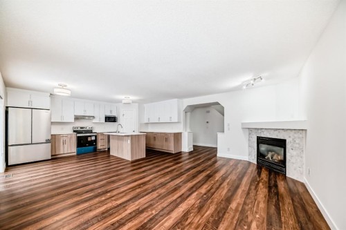 87 Bridlepost Green Sw, Calgary, AB - Indoor Photo Showing Kitchen With Fireplace