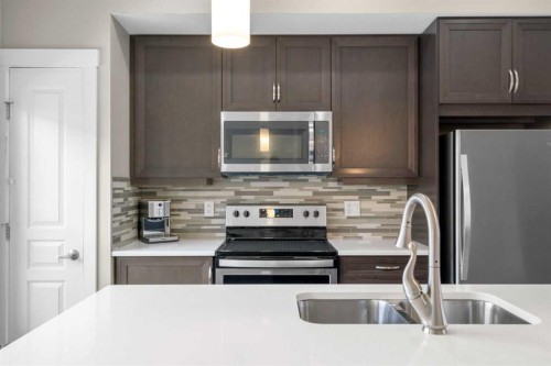 603-32 Horseshoe Crescent, Cochrane, AB - Indoor Photo Showing Kitchen With Stainless Steel Kitchen With Double Sink With Upgraded Kitchen