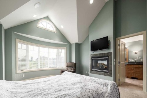 24 Aspen Meadows Green Sw, Calgary, AB - Indoor Photo Showing Bedroom With Fireplace