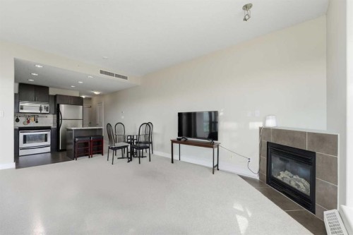 702-77 Spruce Place Sw, Calgary, AB - Indoor Photo Showing Living Room With Fireplace