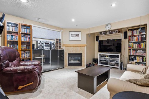 83 Cougarstone Way Sw, Calgary, AB - Indoor Photo Showing Living Room With Fireplace