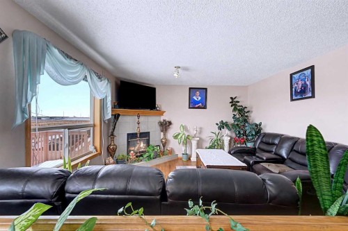 433 Coral Springs Place Ne, Calgary, AB - Indoor Photo Showing Living Room With Fireplace